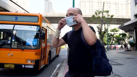 PM2.5 Particle Air Quality Crysis in Bangkok - Man Putting on Mask Because of Unprecedented Hazardous Air Quality Levels in Bangkok, Thailand in January, 2019