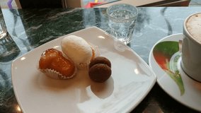 An appetizing Italian breakfast with hot cappuccino and delicious Italian confectionery: rum babà, lady's kiss, cream chantilly. Video 4k 25fps