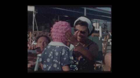 Woman puts Pink bathing cap on embarrassed unhappy little boy 1962
