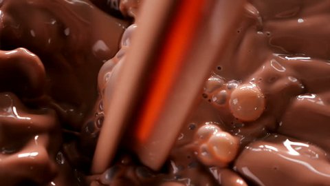 Chocolate milk pouring. Stream of cocoa drink create a swirl and bubbles - top view, slow motion