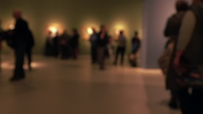 View of people walking during an art gallery exhibition visit. Background with an intentional blur effect applie. 4K Royalty-Free Stock Footage #1023524008