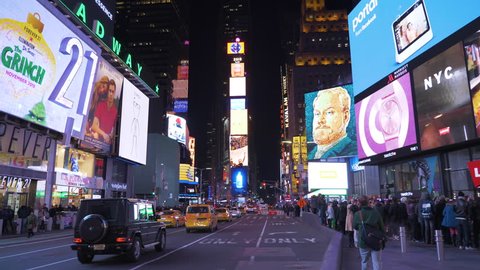 NEW YORK CITY, USA - NOVEMBER 21, 2018: Cars Traffic and People at Times Square at Night. Wide Shot. Camera Tilts Up
