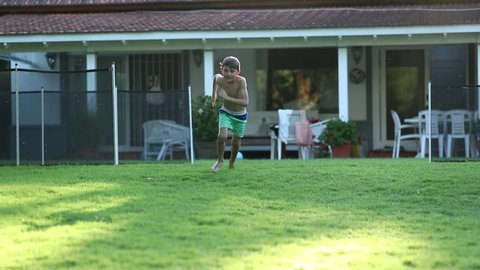 Kid runs outdoors in home garden