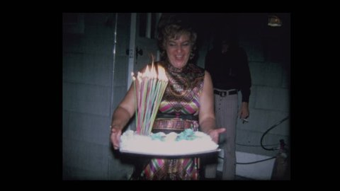Man blows out candles on 50th Birthday cake 1971