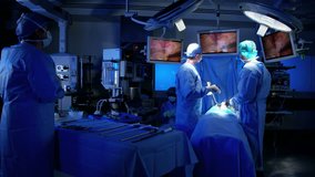 Laparoscopic surgical operation transmitted on hospital monitors performed by female Anesthesiologist training with surgeons wearing surgical mesh and scrubs RED DRAGON