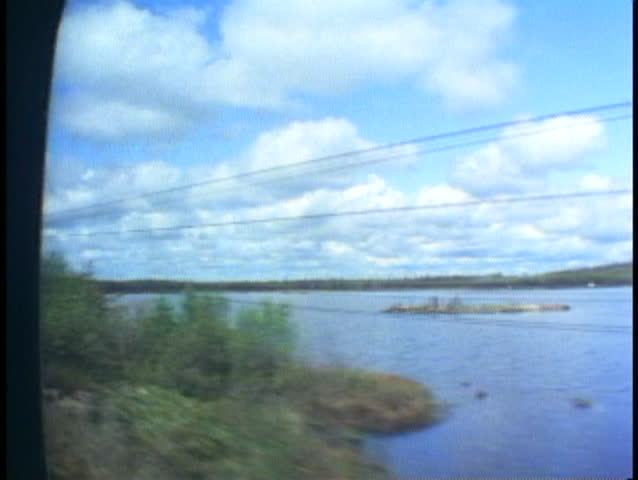 THE CANADIAN TRAIN, 1990, POV out train window, passing lake and pine trees