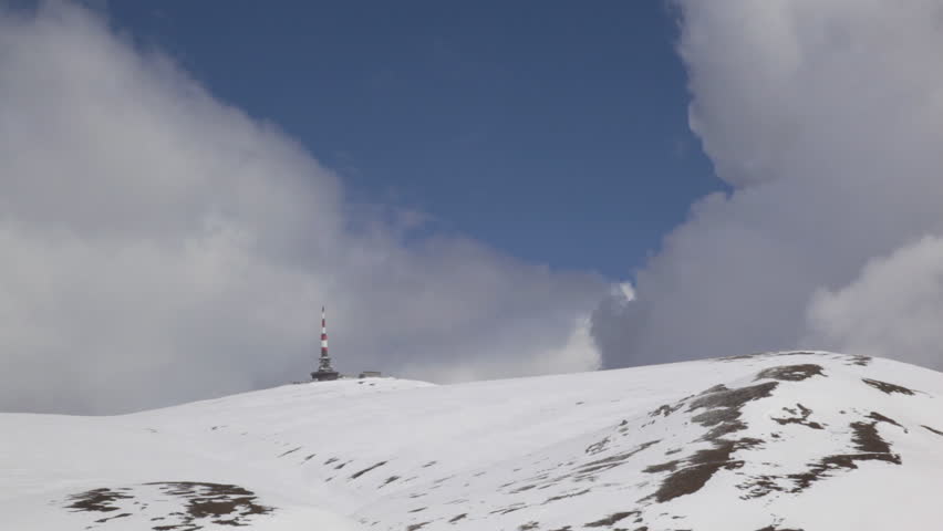 Weather station on snowy mountain peak, time lapse