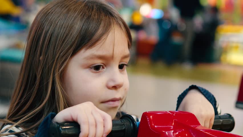Little caucasian child having fun playing on the recreational area in modern mall. Little girl on the children play room in shopping mall.