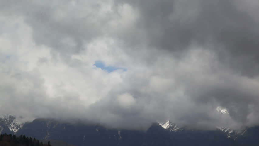 Stormy clouds zoom out to green meadow