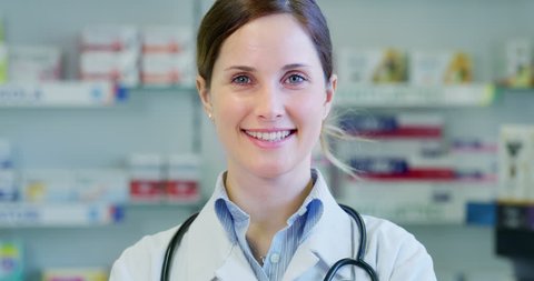 Slow motion close up of a beautiful young woman pharmacist consultant smiling in camera. Shot in 8K. Concept of profession, medicine and healthcare, medical education, pharmaceutical sector