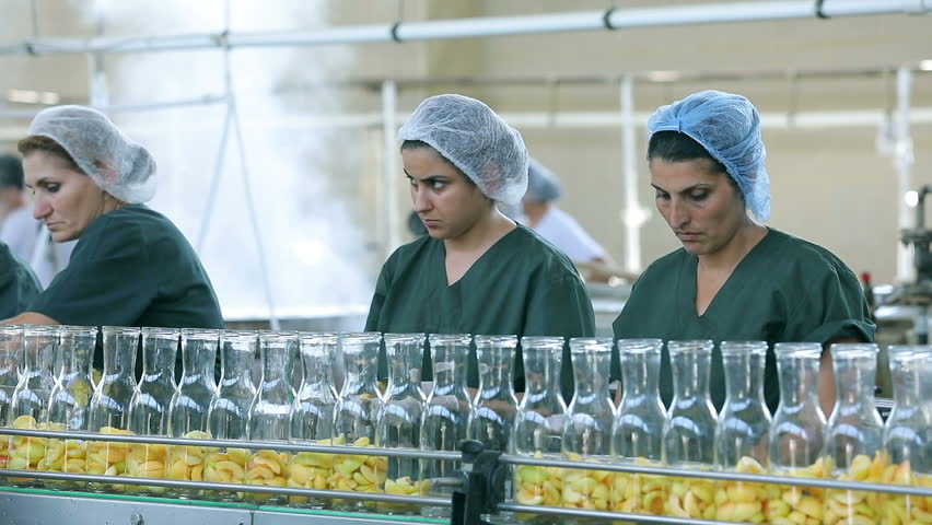 Production of Apricot Juice and Canned Fruits Products . Workers on line of bottling fresh apricots . Produce line inside plant . Processing of fruits , apricots in a cannery . Canning Factory .
