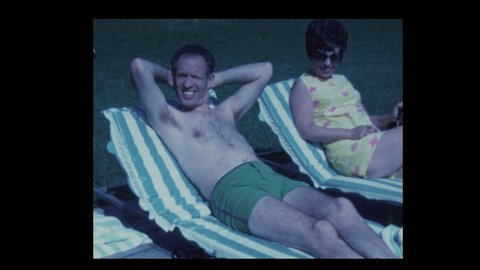 1971 Husband and wife relaxing by hotel pool