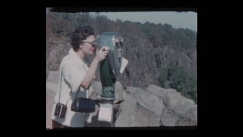 1955 Glam 50s woman peers through coin operated binoculars at Viewpoint