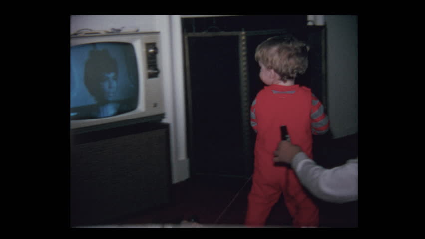1971 Grandparents watching Baby boy and vintage television set