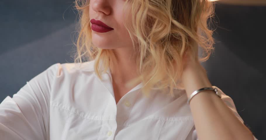 The girl preens looking at her smartphone, straightens her hair