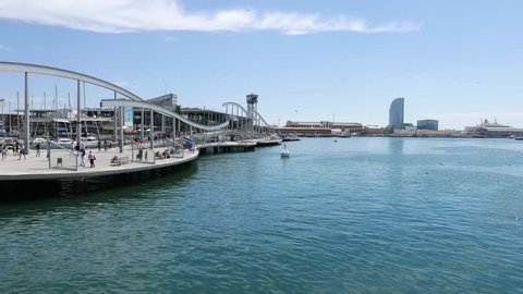Barcelona, SPAIN - AUGUST, 18, 2018: Sailing along Rambla del Mar boardwalk at Port Vell, Barcelona. Sightseeing boat trip and sea panorama, view on Maremagnum Shopping Centre and yachts in marina