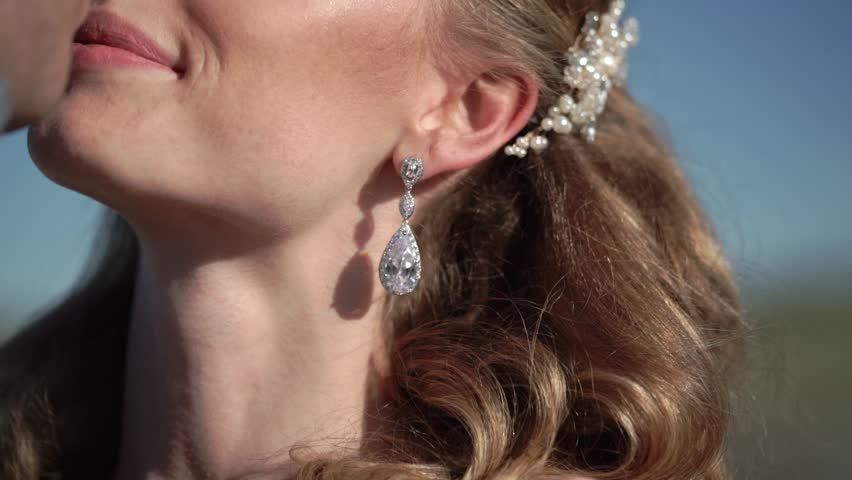 Young beautiful bride in a wedding dress and groom hugging and kissing outdoors