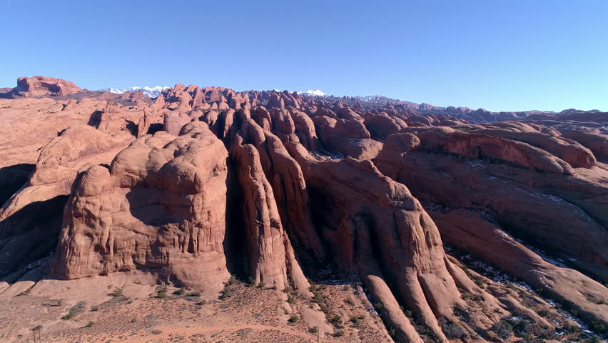 Aerial view flying over desert fins viewing the landscape in Moab Utah looking at Behind the Rocks area towards the La Sal Mountains.