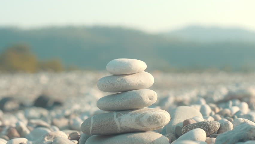 Stone balance closeup. Female hand making pebbles tower from sea stones. Macro of pyramid of pebbles on beach. Stack of stones on seashore. Meditation and relax on summer vacations concept Royalty-Free Stock Footage #1023616357
