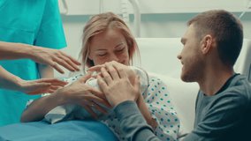In the Hospital Midwife Gives Newborn Baby to a Mother to Hold, Supportive Father Lovingly Hugging Baby and Wife. Happy Family in the Modern Delivery Ward. - Powered by Shutterstock - Get 15% off with code: PIKWIZARD15