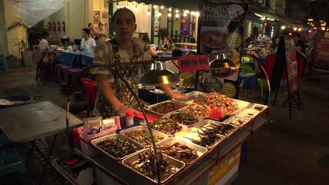 BANGKOK,  THAILAND - CIRCA OCTOBER 2018 : View of man selling various kinds of INSECTS and BUGS at KHAO SAN ROAD.