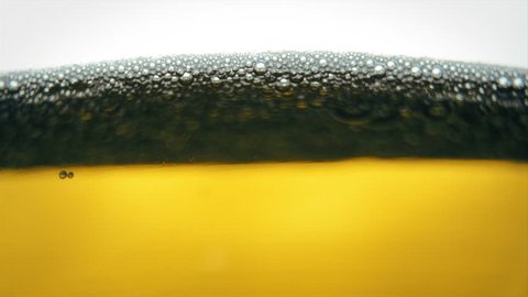 Pouring yellow beer on white background. Barm, bubble fresh drinking, foamy golden alcohol.