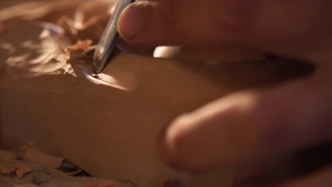 Extremely Close Up of Man’s Hands doing Artistic Wood Carving. Producing an Ornament on Wood with Chisel and Hammer on a Panel of Wood Carved Decoration. Handicrafts. Furniture Production. Handmade.