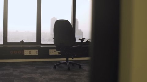 An empty office with a chair in the middle - vacant room or abandoned company building - no jobs financial crisis or market crash - bankrupt technology tycoon or brand new manager ceo space with view