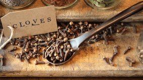 Top view of clove spices on wooden board. Selective focus. Tracking shot.
