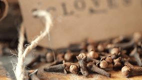 Close up footage of clove spices on wooden board. Selective focus. Panning to the right.