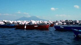 Wooden Boats at anchor in front of Vesuvius in Italy. Napoli