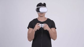 Young handsome multi-ethnic man playing games and using virtual reality headset