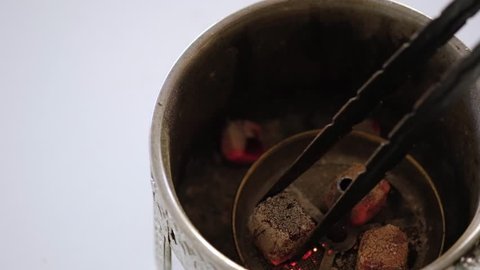 Burning coconut coal for hookah in a special professional stove