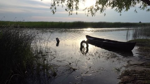 Old wooden boat in Danube Delta area at sunset, Romania