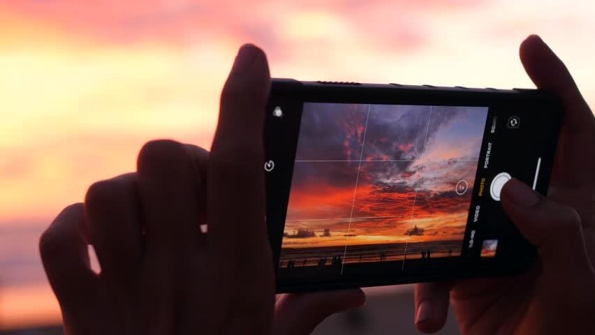 Female Hands Holding Smartphone and Doing Nature Photography. Young Tourist Woman Taking Photos with Mobile Phone Camera of Amazing Sunset at the Beach. 4K Slowmotion. Bali, Indonesia. | Shutterstock HD Video #1023667792