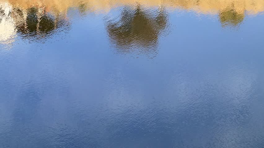 reflection of the slope of the field in the clear water of the river