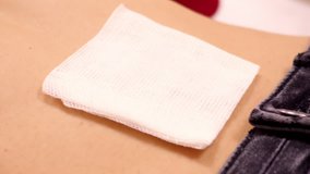 closeup slow motion large white cotton napkin lies on girl belly near jeans belt after piercing  - Powered by Shutterstock - Get 15% off with code: PIKWIZARD15