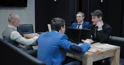 Young businessmen are having a conversation. Corporate meeting in the meeting room. Modern workplace in the office.