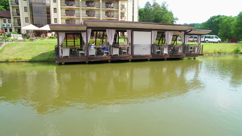 Aerial view. Two young people are sitting at a restaurant near the lake