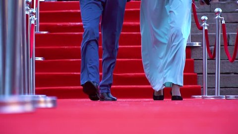 Low angle close up shot of a man and a woman walking on the red carpet