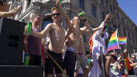 OSLO, NORWAY - JUNE 30, 2018: Young people sing and dance standing on a moving platform. The Pride Parade, the highlight of Oslo’s Pride Week, is a huge, vibrant parade filling the city’s streets.
