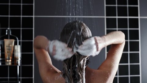 Woman washes her hair with shampoo in the shower with, hair care, ceratin mask, rinse shampoo and balm, strong hair, washing hair