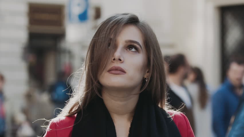 Surprised pretty woman laughing among street traffic. Slowly