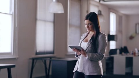 Young Attractive business woman holding an tablet in an office