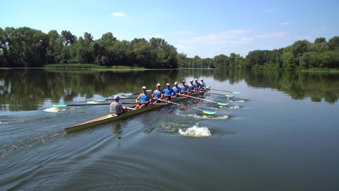 Rowing team summer training. 8 athletes rowers in a boat in the river