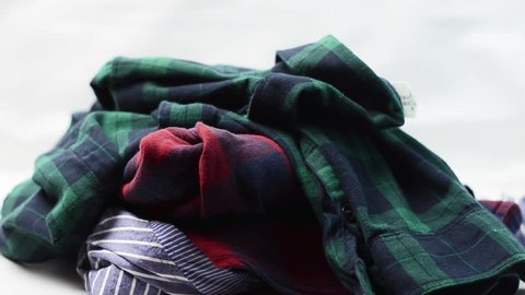 Jeans and plaid shirts falling on the table in a stack