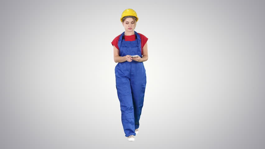 Female constuction worker counting money while walking on gradient background.