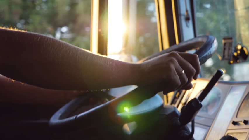 Unrecognizable man holding his hands on steering wheel and driving car at country road on warm summer day. Truck driver rides to destination. View from the lorry cab. Slow motion Close up | Shutterstock HD Video #1023713953