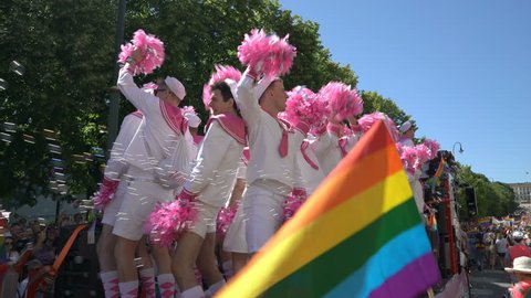 OSLO, NORWAY - JUNE 30, 2018: Guys wearing pink sailors suits dance and sing on a moving platform. The Pride Parade, the highlight of Oslo Pride Week, is a huge, vibrant parade filling the city