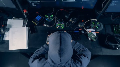 A person cracking computer. Hacker cracks system, using computer.
